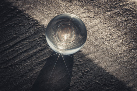crystal ball on the sand, closeup of photo with vignette