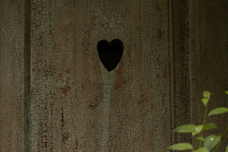Heart shaped hole in a wooden wall. Valentine's day background.の写真素材