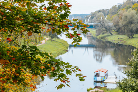Autumn landscape with river and colorful trees in the city park.の写真素材