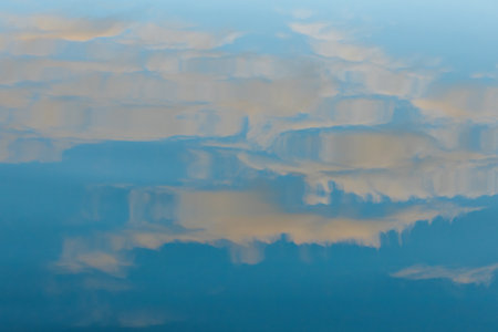 Clouds reflected in the water. Blue sky with white clouds.の写真素材