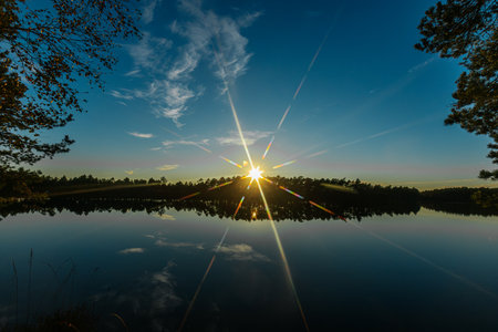 Sunset on the lake in the forest. Beautiful summer landscape.の写真素材