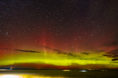 Aurora borealis in the night sky over the sea.の写真素材