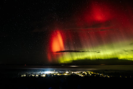 Aurora borealis in the night sky above the sea.の写真素材