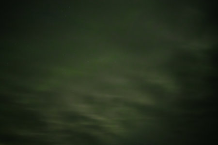 Night sky with stars and clouds. Long exposure photograph, with grain.