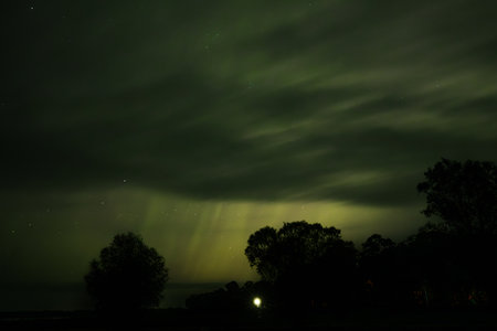 Aurora borealis in the night sky over the lake.の写真素材
