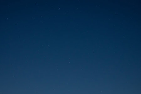 Night sky with stars and moon in the background. Long exposure photograph.の写真素材