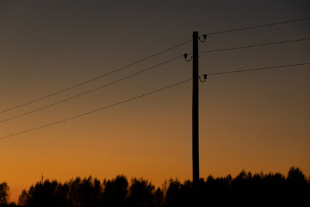 Silhouette of a power line against the background of the setting sunの写真素材