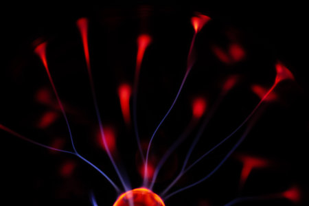 Close-up of a red electric fan on a black background.の写真素材