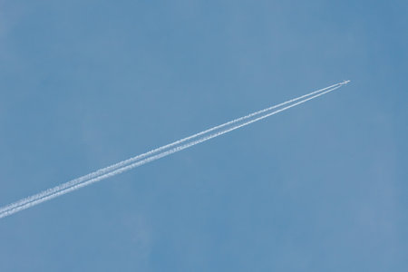 airplane trail in the blue sky, note shallow depth of fieldの写真素材