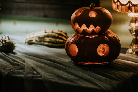 Halloween pumpkins on table in dark room, retro toned