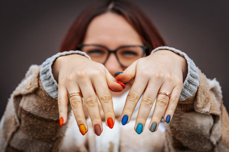 Close up portrait of a beautiful young woman with colorful manicure.の写真素材