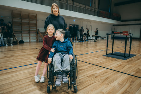 Disabled handicapped boy in wheelchair with his mother on the background.のeditorial素材