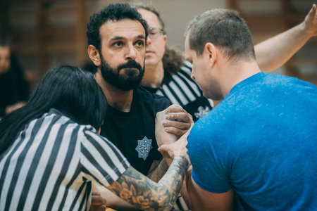 Tattooed man in a blue T-shirt with tattoos on his armsのeditorial素材