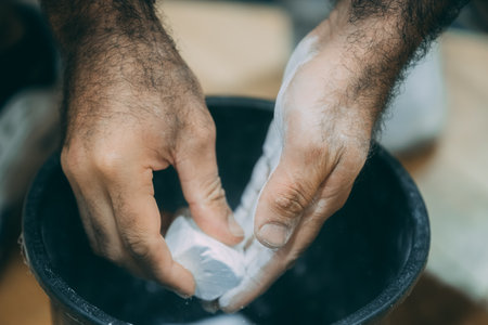 Close up of a man's hands cleaning a bucket with white foamのeditorial素材