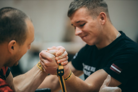 Personal trainer helps a young man to use a resistance band in a gym.のeditorial素材