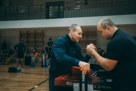 Caucasian male trainer assisting senior man during workout at gym.のeditorial素材