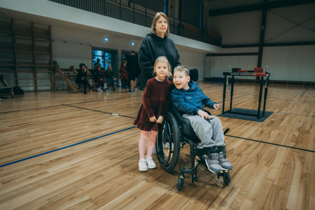 Senior woman in a wheelchair with her two children in a gym.のeditorial素材