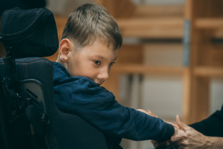 little boy sitting in school backpack and looking at teacher with serious faceのeditorial素材