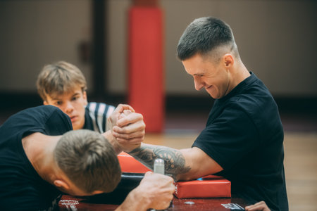 Father and son are training in the gym. Father helps son to do exercises.のeditorial素材