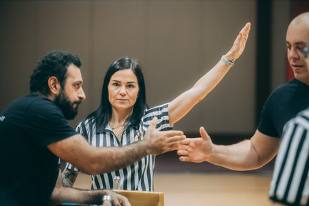 Female referee talking to a man during a basketball game in a courtのeditorial素材
