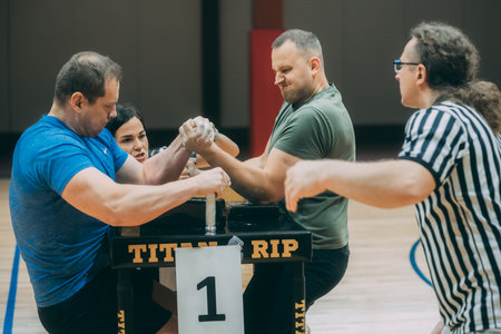 Fitness coach helping senior man to do kettlebell exercise in gym.のeditorial素材