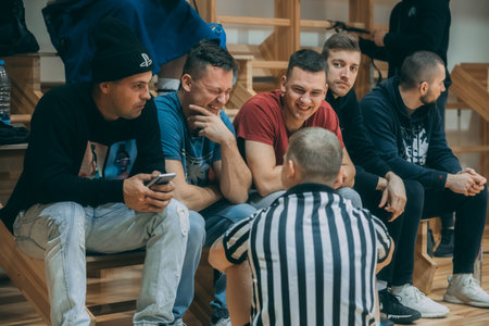 Group of young people sitting on the stairs and playing video games.のeditorial素材
