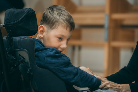 Cute little boy sitting in a chair with his mother at homeのeditorial素材