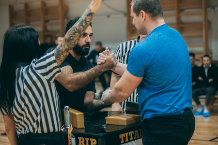 Tattooed man in a black t-shirt and with a tattoo on his arm is fighting with another man.のeditorial素材