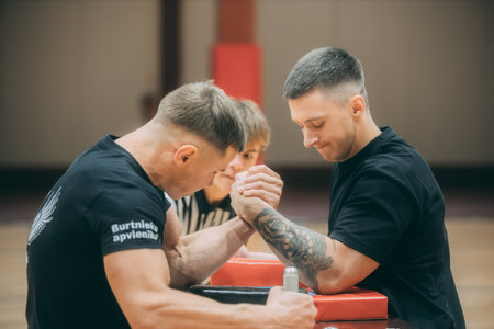 Personal trainer helps a teenage boy to do exercises in the gym.のeditorial素材