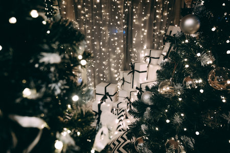 Holiday setting with two Christmas trees, sparkling lights, and decorative ornaments, surrounded by neatly wrapped gifts, evoking a joyful festive ambianceの写真素材