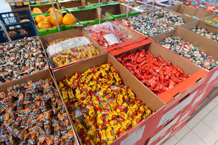Valmier, Latvia - November 24, 2025: Assorted candies displayed in cardboard boxes at grocery store, featuring vibrant colors and enticing packaging for candy enthusiastsのeditorial素材