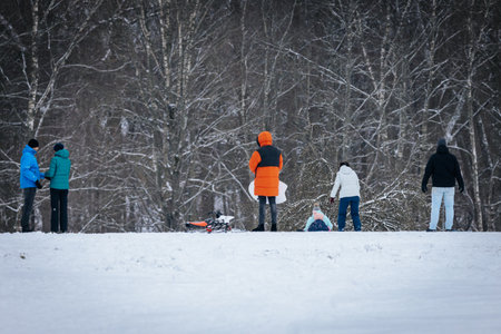 Valmiera, Latvia - January 02, 2026: Diverse group of people engaging in winter fun in snowy...