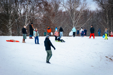 Valmiera, Latvia - January 02, 2026: Diverse group of individuals engaging in winter fun on snowy...