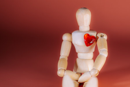 Wooden mannequin figure displays a red heart on its chest, set against a soft gradient background,...