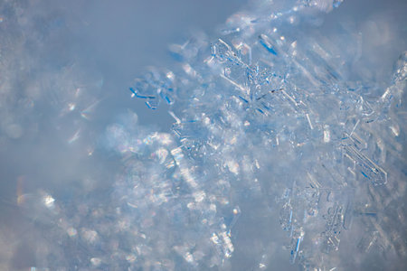Detailed close-up of snowflakes displaying unique crystalline patterns and sparkling ice particles,...