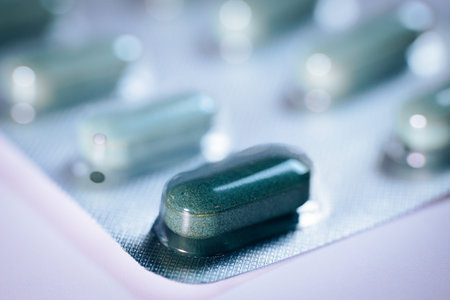 Close-up of green capsules displayed on a blister pack, highlighting their glossy texture and unique...