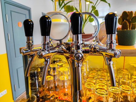 Balvi, Latvia - February 22, 2026: Chrome beer tap handles with black grips are mounted on a bar...