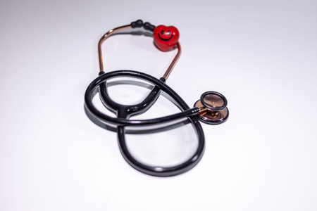 Stethoscope featuring a red heart-shaped accessory on a clean white background, highlighting its use...
