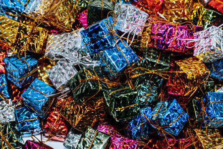 A collection of vibrant small gift boxes in metallic colors stacked together, showcasing shiny...