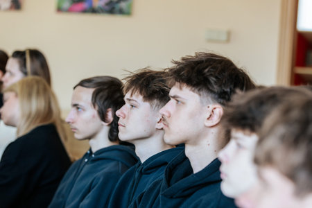 Valmiera, Latvia - March 17, 2026: Young individuals in black hoodies are seated in a row, showing...