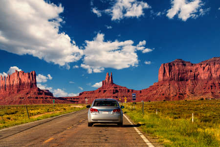 Highway in Monument Valley, Utah / Arizona, USA - Picture with road and cars driving towards the hills. Photo made during a road trip throughout the western states.の写真素材