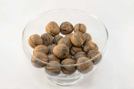 walnuts in a glass dish on a white background