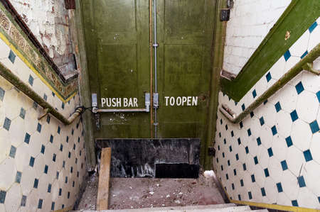 Old devastated stairway with the door closed.の写真素材