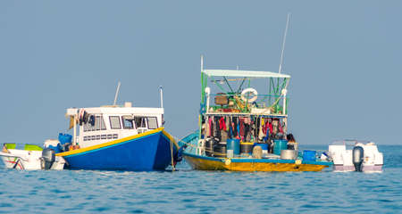 Maldives. Worker boats near the island of Fulidhoo.