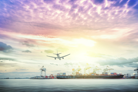 Logistics and transportation of international container cargo ship and cargo plane with ports crane bridge in harbor at sunset sky for logistics import export background and transportation industry.の写真素材