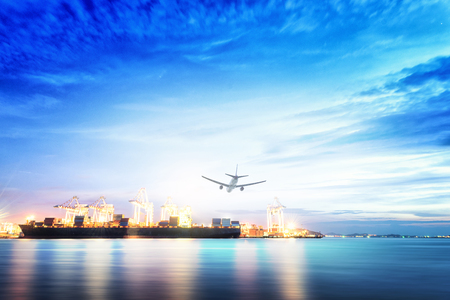 Logistics and transportation of international container cargo ship and cargo plane with ports crane bridge in harbor at sunset sky for logistics import export background and transportation industry.の写真素材