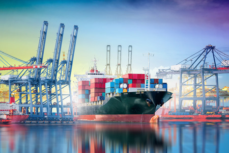 International Container Cargo ship with working crane bridge in shipyard background, logistic import export background and transport industry.の写真素材