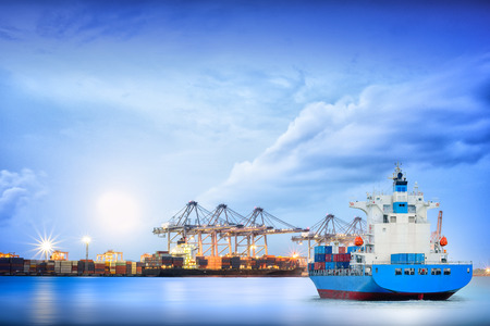Logistics and transportation of International Container Cargo ship with ports crane bridge in harbor for logistics import export background and transportation industry.の写真素材