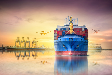 Logistics and transportation of international container cargo ship and cargo plane with ports crane bridge in harbor at sunset sky for logistics import export background and transportation industry.の写真素材