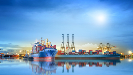 Logistics and transportation of International Container Cargo ship with ports crane bridge in harbor for logistics import export background and transportation industry.の写真素材